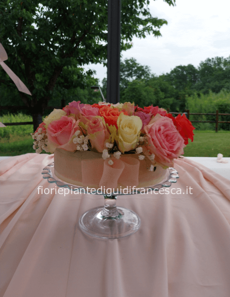 Composizione a forma di torta di fiori recisi su alzata in vetro